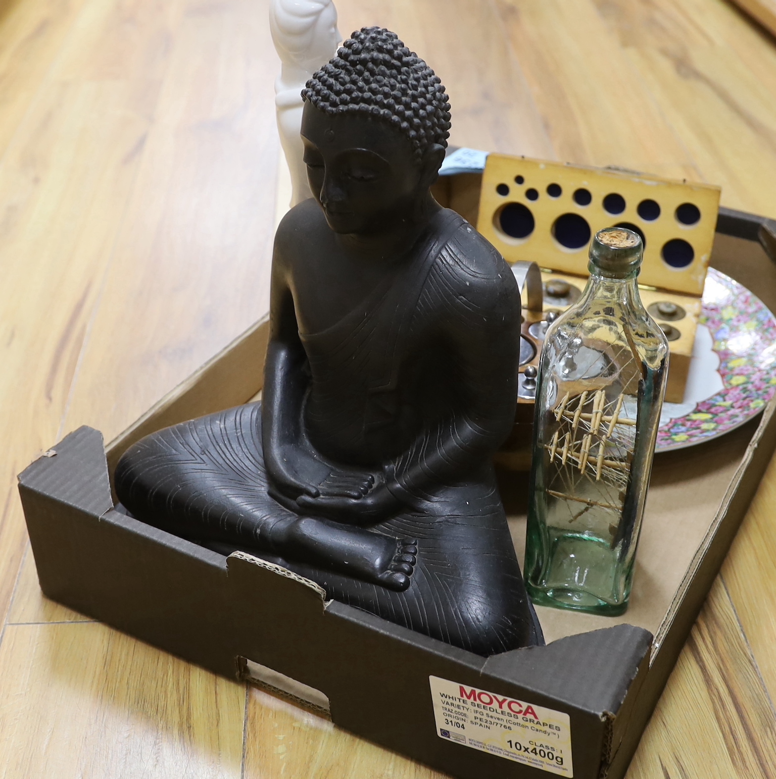 Sundry items including two graduated sets of weights, a ship-in-bottle, a large cast Buddha and a blanc de Chine figure, the largest 37cm high